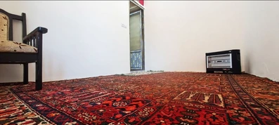 اتاق کف خواب اقامتگاه بومگردی خانه مادری نجف آباد با فرش قرمز